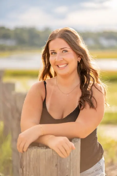 Mia Webster, smiling, outdoors at sunset